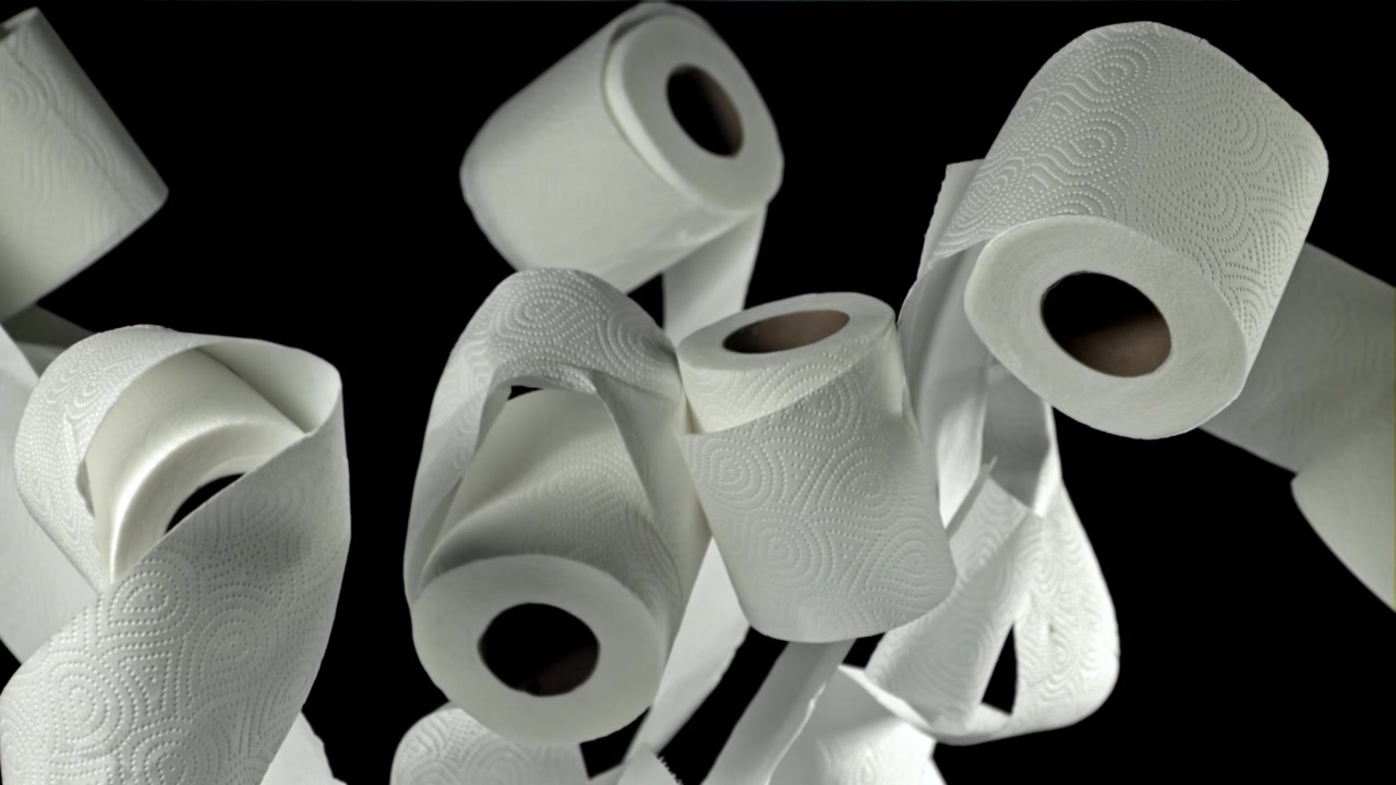 White Toilet Paper Rolls Floating Upwards on Black Background