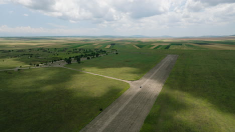 Car-driving-on-wide-runway-of-Shiraki-military-airfield-in-Georgia