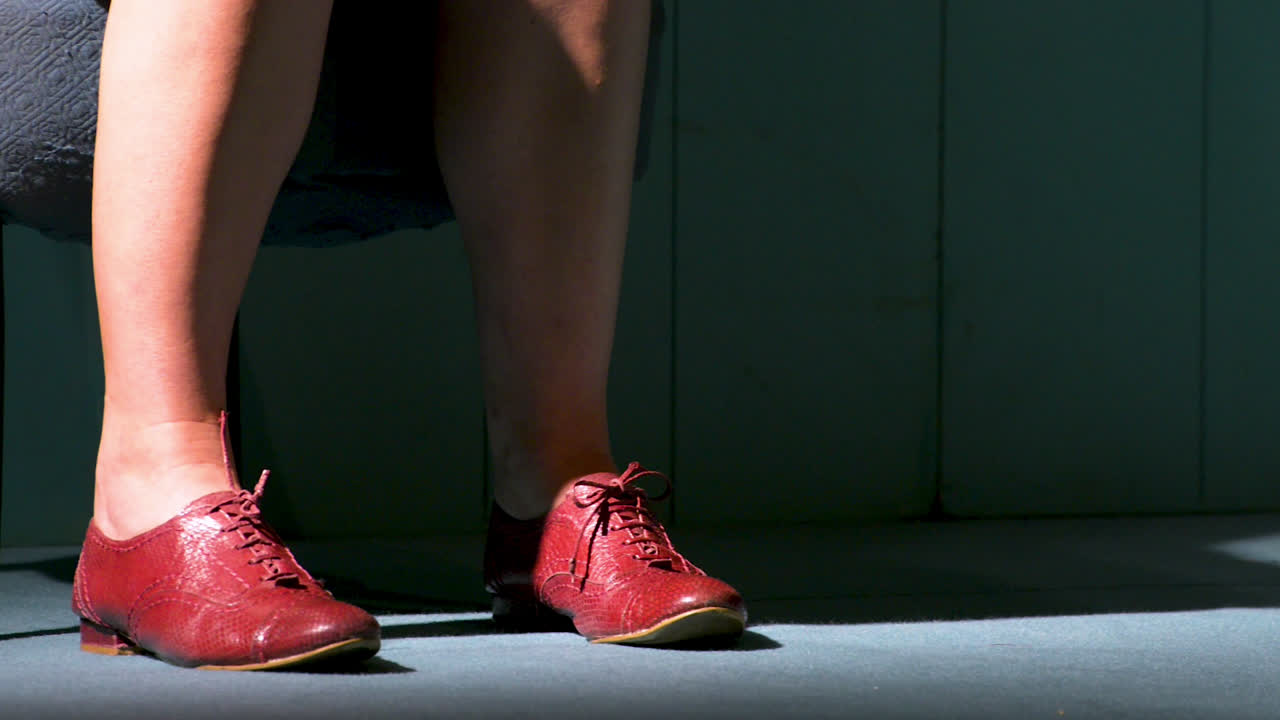 방에 있는 오래된 의자에 앉아 있는 동안 여자 발과 다리를 닫습니다