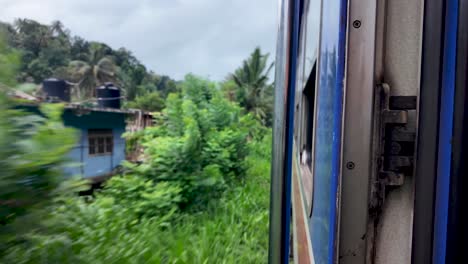 pov outside blue train, silver handrail, train journey through sri lanka