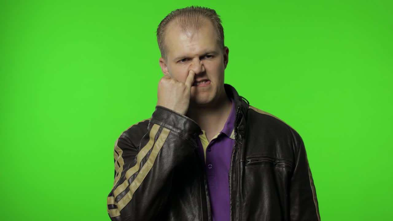 hombre gracioso y estúpido picando la nariz, expresión humorística sin cerebro, quitando las mucosas, malos modales.