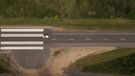 toma aérea de arriba hacia abajo de la conducción de automóviles en la carretera de la pista de aterrizaje de emergencia en uruguay