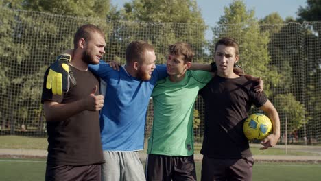 positive united football team posing on the pitch