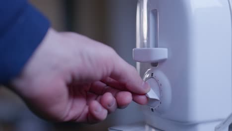 Caucasian-hand-pushing-down-lever-of-white-toaster