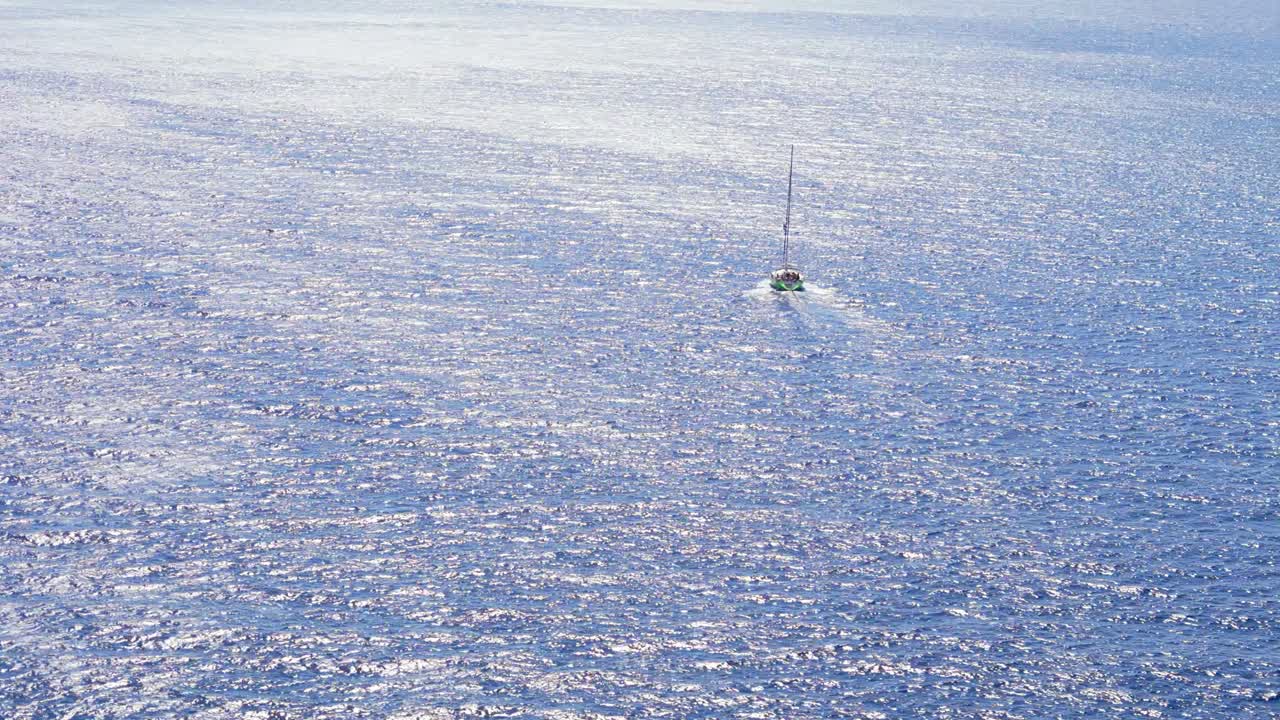 세일보트는 모터를 사용하여 현재, 깊은 파란색, 모험의 넓은 바다에 대항하여 열린 바다로 운전합니다.