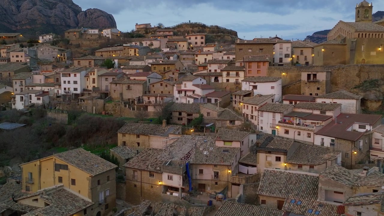 Vista aérea de un pueblo medieval español al anochecer.
