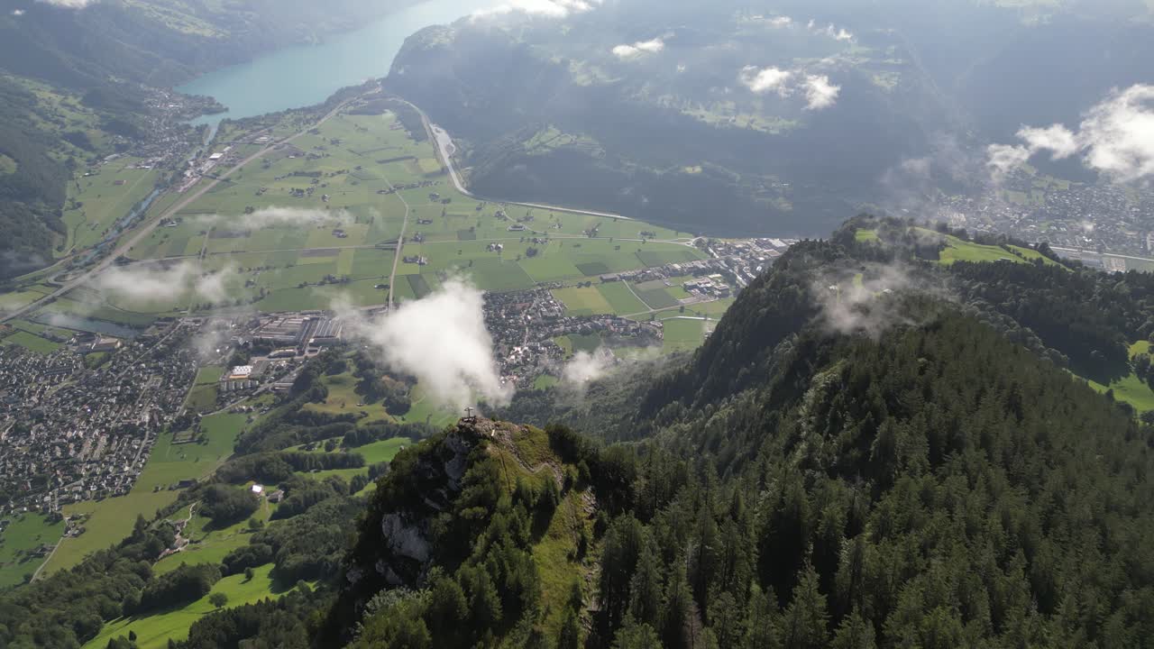 The aerial view of a lush green valley with a clear blue sky and clouds in background provides a breathtakingly beautiful and peaceful scene the valley's natural beauty makes it the perfect backdrop
