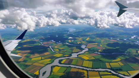 aerial view of winding river and fields from airplane window
