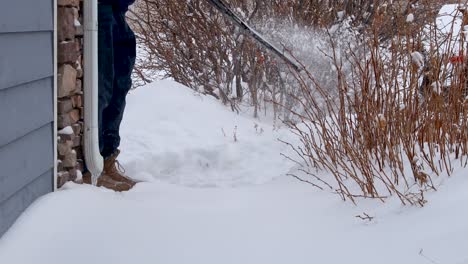 Ein-Mann-Reinigt-Eine-Rutschfeste-Verbindungslauffläche,-Um-Zu-Verhindern,-Dass-Menschen-Im-Schnee-Ausrutschen