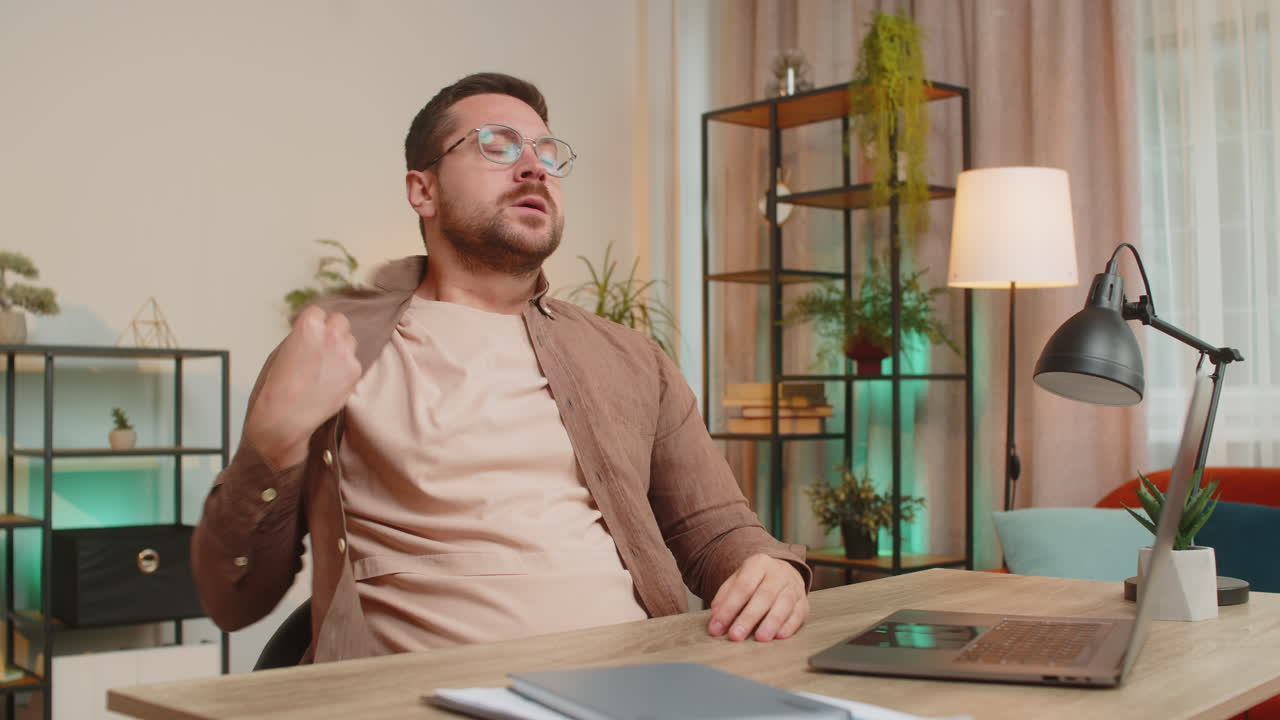 Sad caucasian young man freelancer looks pensive thinks over life concerns sitting at desk at home