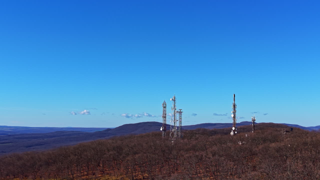 Torri su una collina nella foresta sotto un cielo azzurro limpido durante il giorno, con montagne distanti visibili sullo sfondo