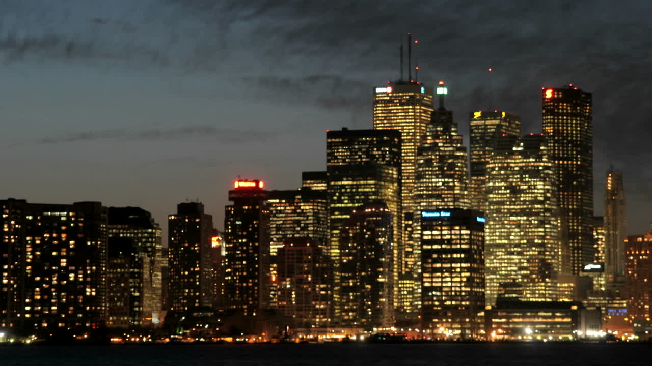 el horizonte de toronto brilla con luz bajo el cielo oscurecido