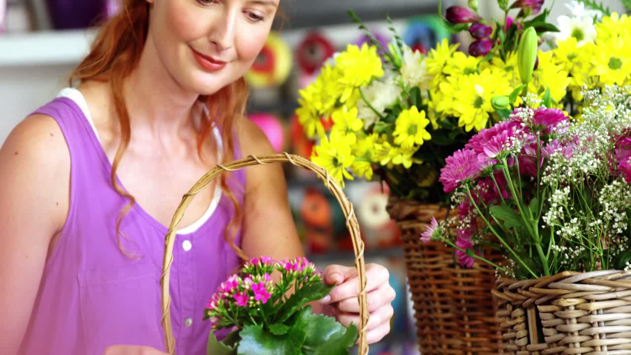 Female florist arraigning flower in wicker basket