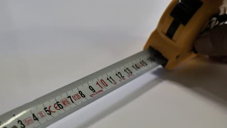 tape measure. hands pull the measuring yellow tape out. roll of measuring tape. scene c.