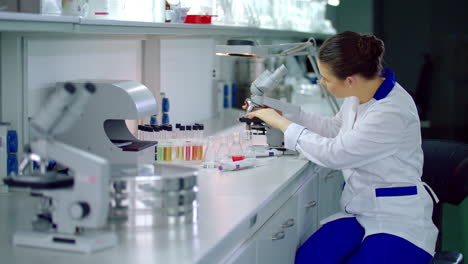 lab researcher working with microscope in laboratory