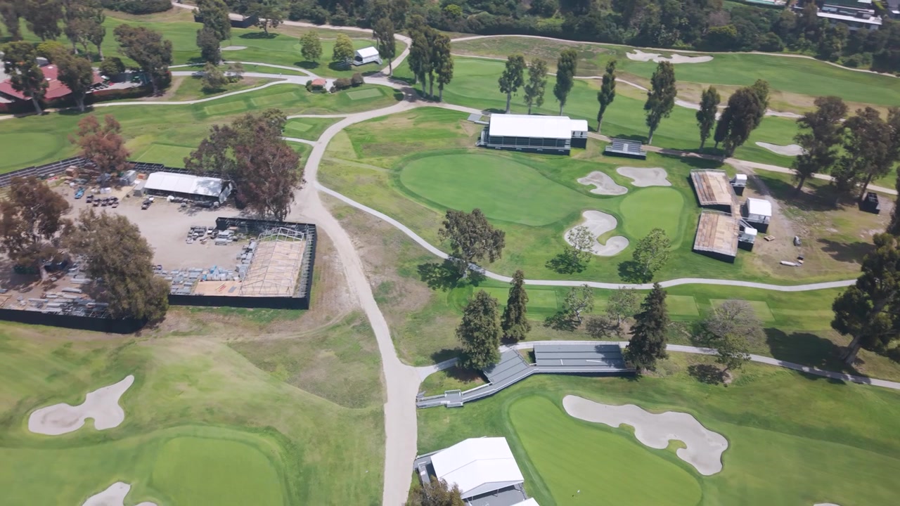 Luxury Riviera Country Club golf course in Pacific Palisades California with green fairways, sand bunkers and white event tents on a sunny day in the USA. Aerial top down shot.