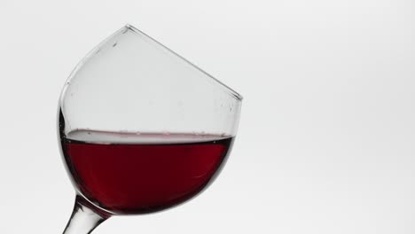 Close-up-of-a-drop-falling-in-glass-with-red-wine.-Rose-wine-on-white-background