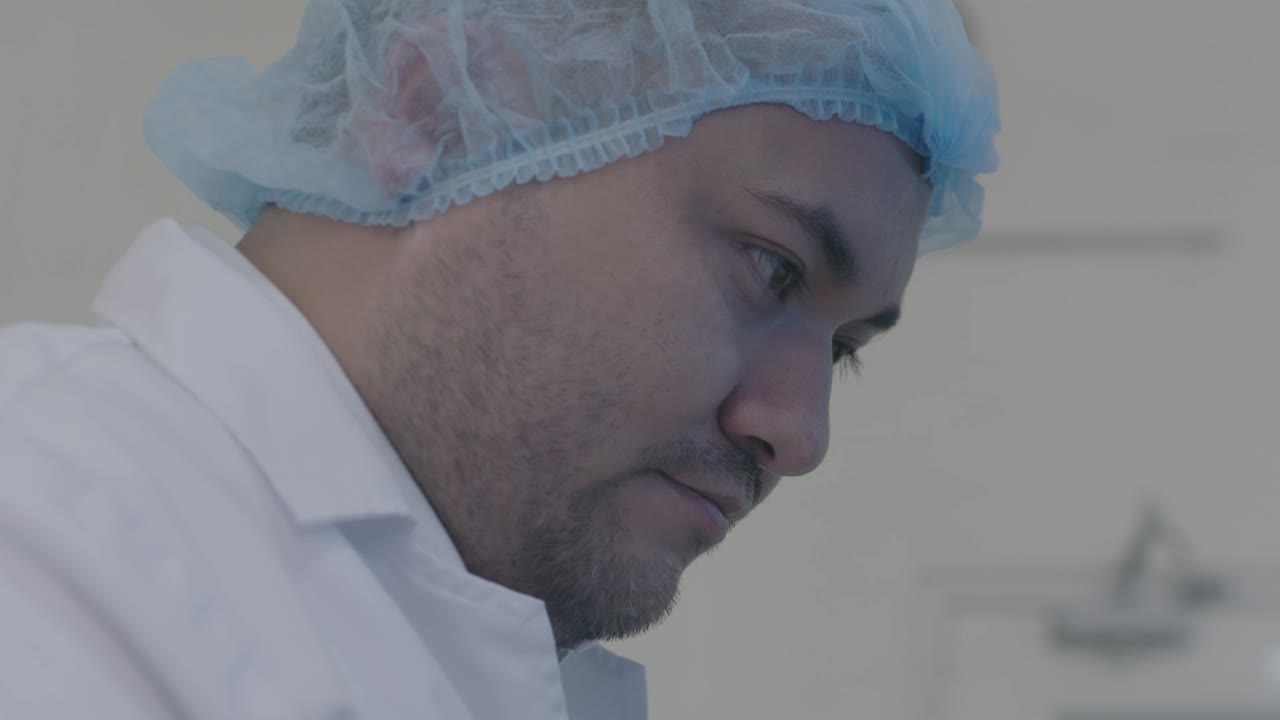 close-up view of a researcher wearing a hospital cap, deeply focused on the process and quality control.