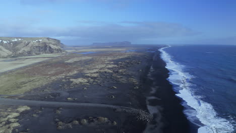 foamy waves splashing on black sand beach at vik in south of iceland