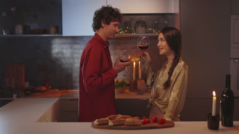 couple enjoying a romantic evening with wine in the kitchen