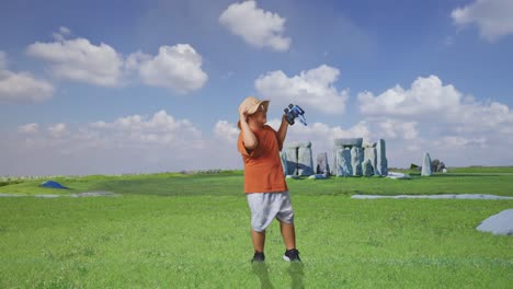 asian boy with a hat holding binoculars and dancing. boy researcher examines something while traveling in stonehenge, travel tourism adventure concept, full body