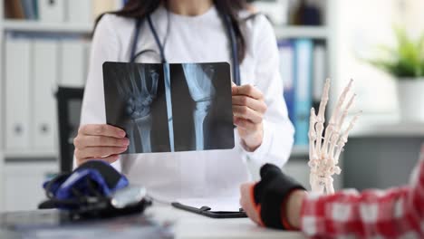 doctor showing hand x-ray to a patient during a medical consultation