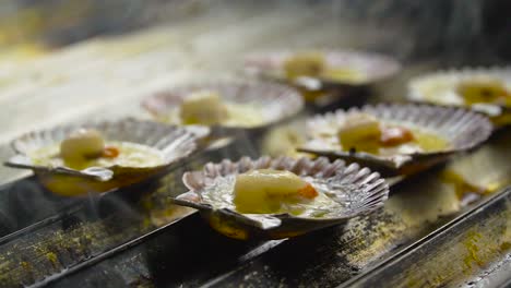 several oyster shells are being cooked on a metal stove