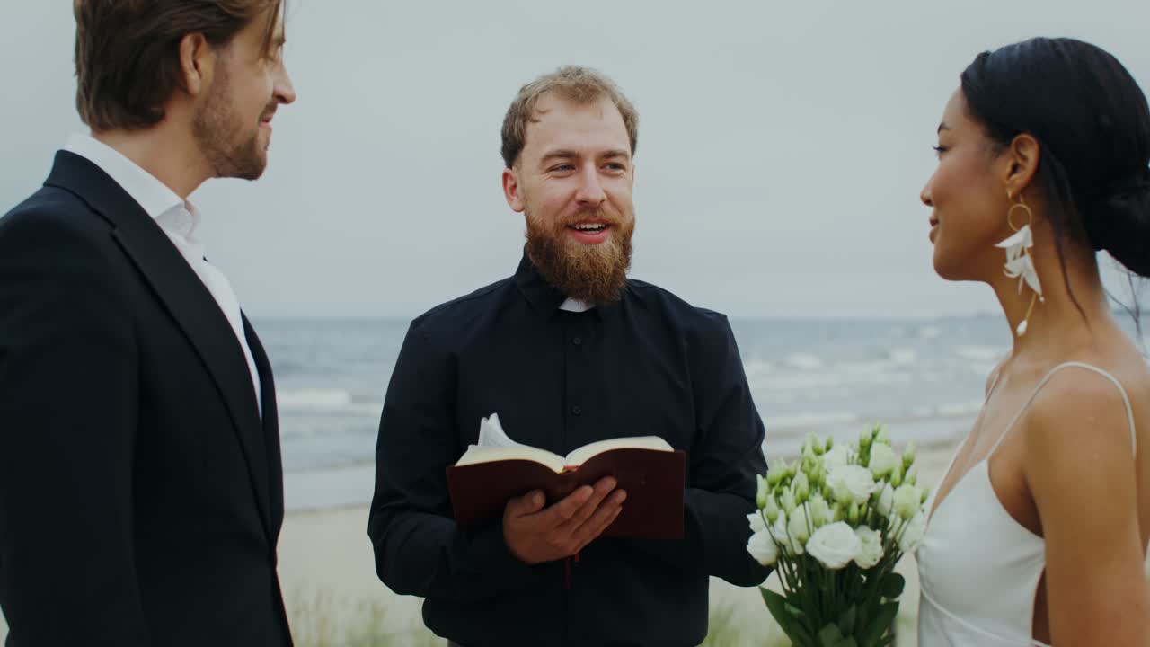 Beach Wedding Ceremony with Bride, Groom, and Officiant