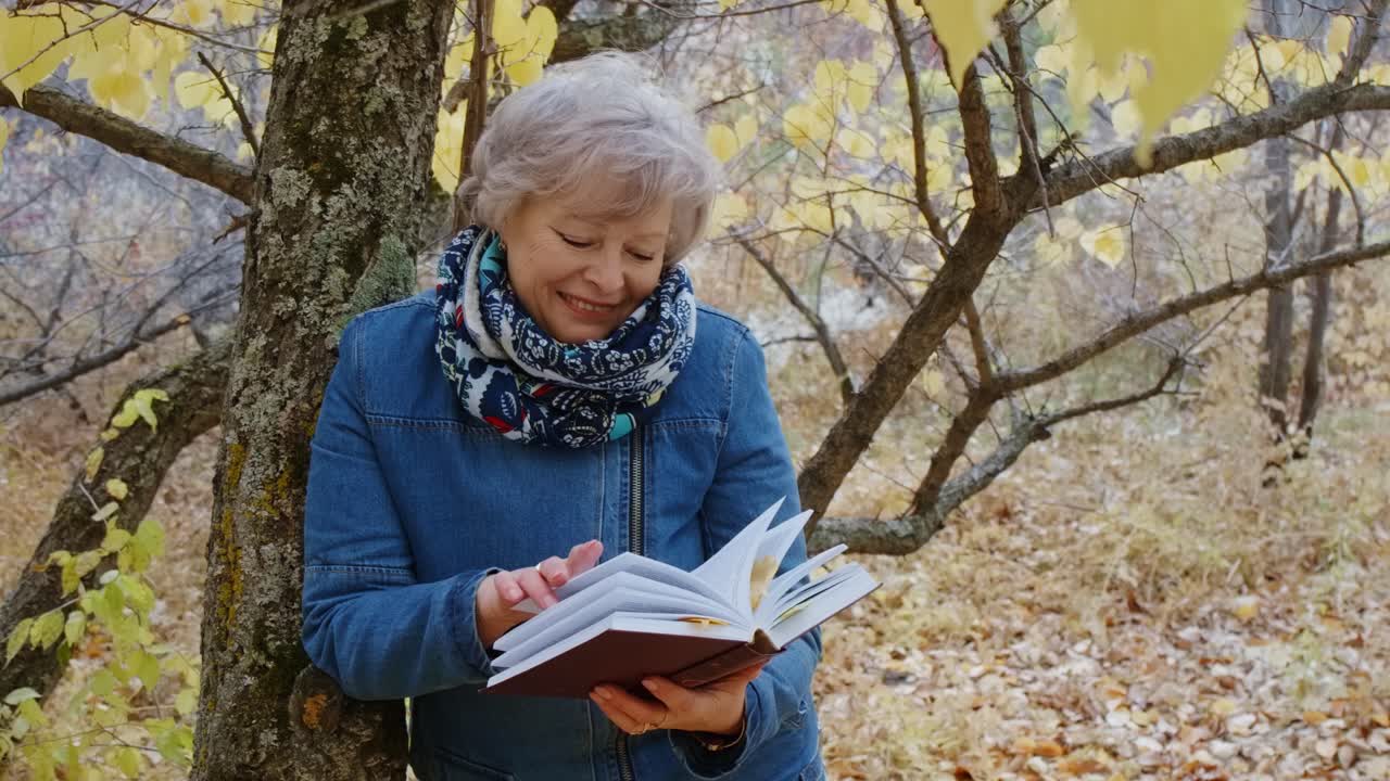 Senior Woman Reading in Autumn Park