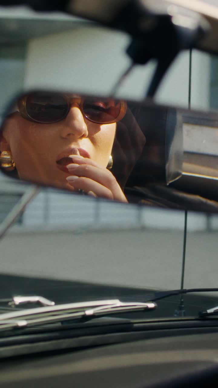mujer aplicando lápiz labial en el coche