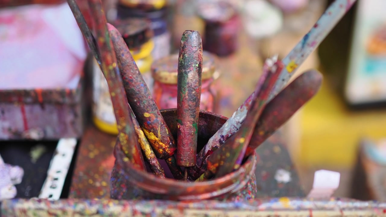 Paint-Stained Artist Brushes Standing in a Glass Jar