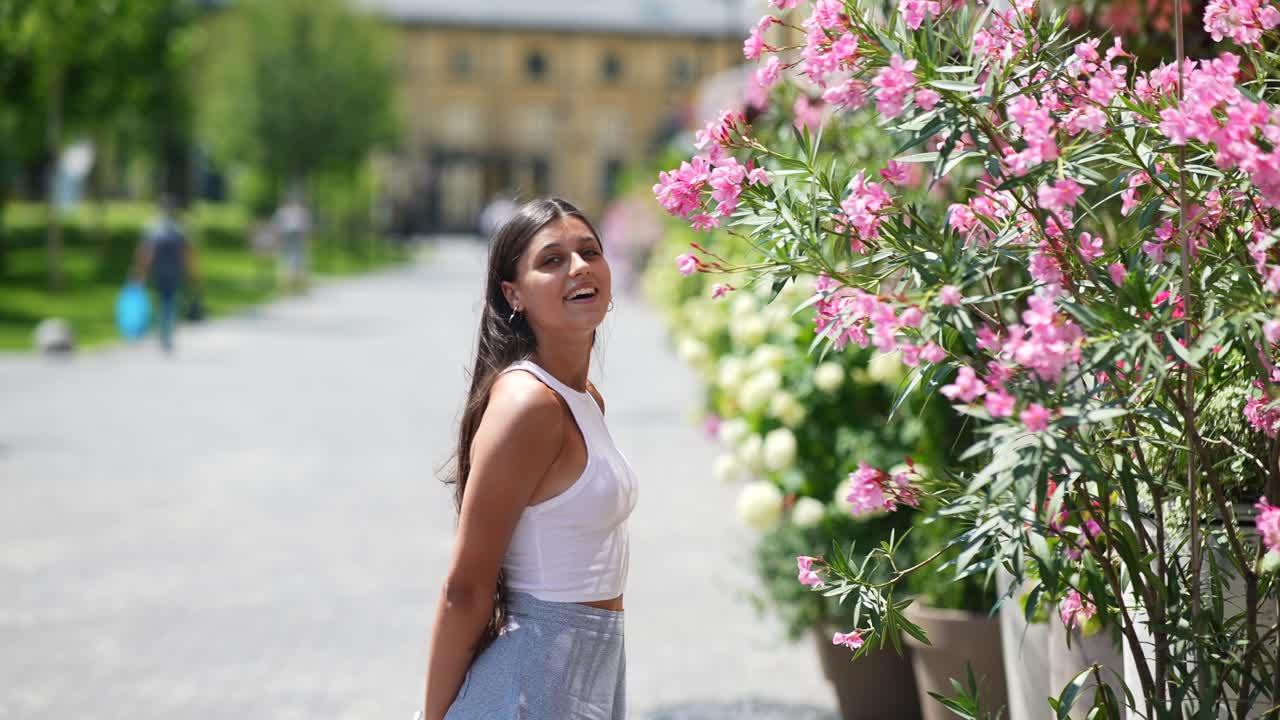 mujer disfrutando de flores en un parque de la ciudad