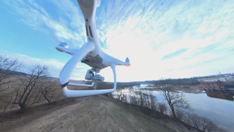 side view of dji phantom quadcopter drone flying forward towards the winding river