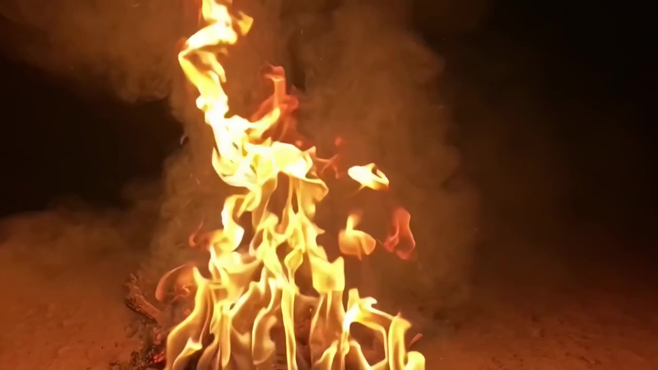 Fiamme vivaci con fumo su uno sfondo scuro