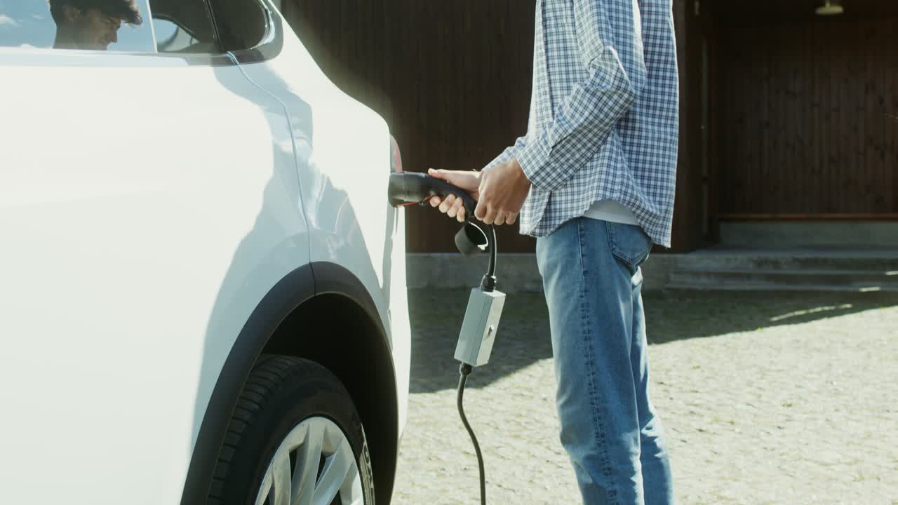 hombre cargando un vehículo eléctrico en casa