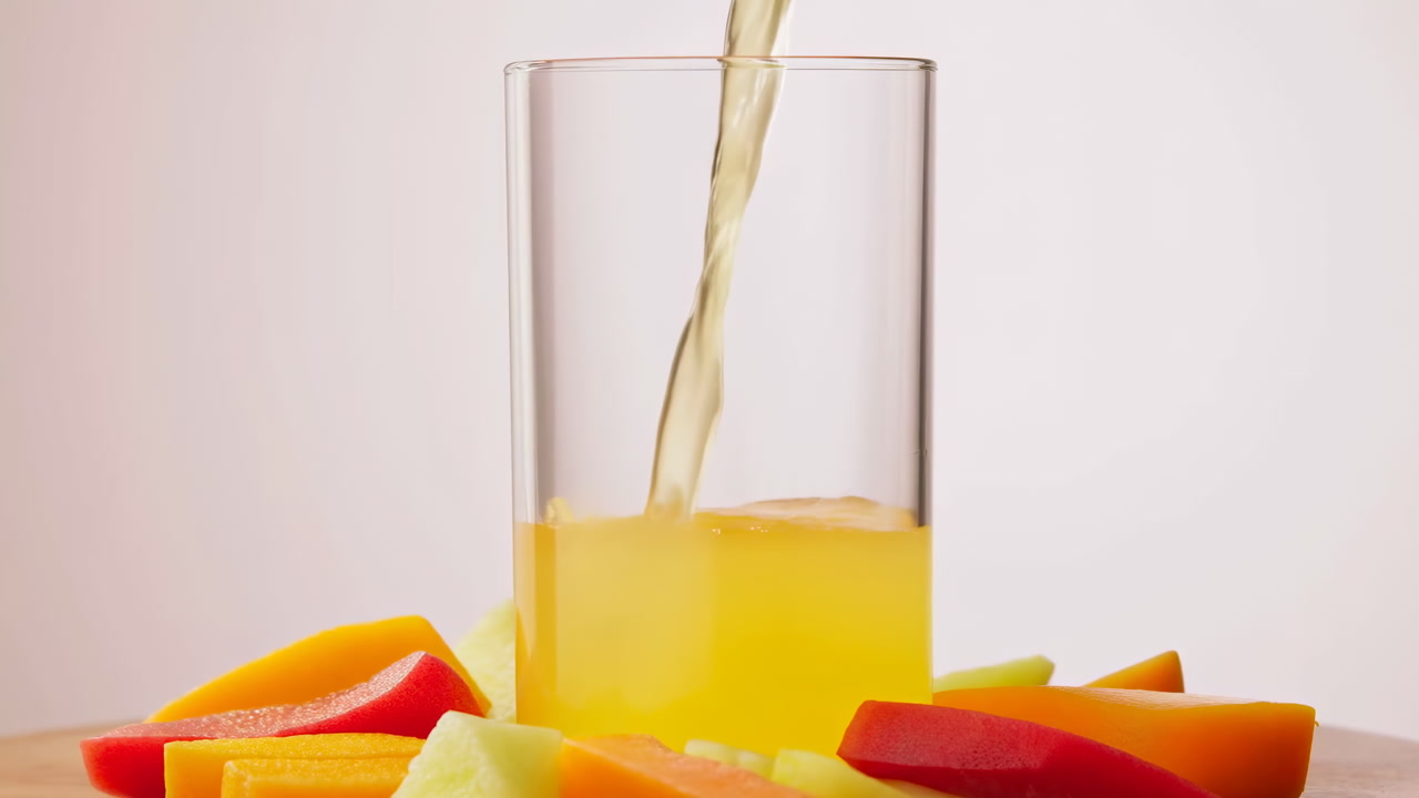 Glass Being Filled With Tropical Juice, Surrounded By Colorful Mango Papaya Melon Slices On Wooden Table,
