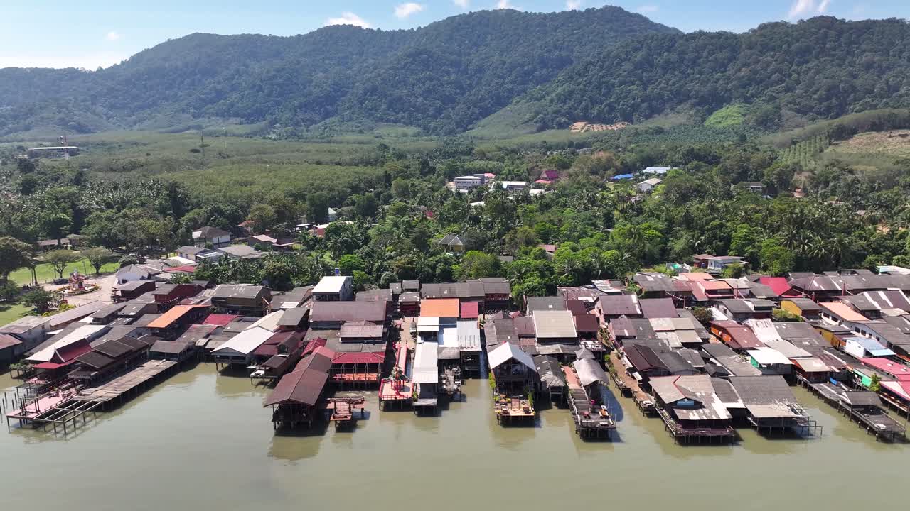Amazing old town, wooden fishing village buildings on shore, mountain backdrop. Koh Lanta, Thailand