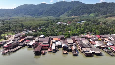amazing old town, wooden fishing village buildings on shore, mountain backdrop. koh lanta, thailand