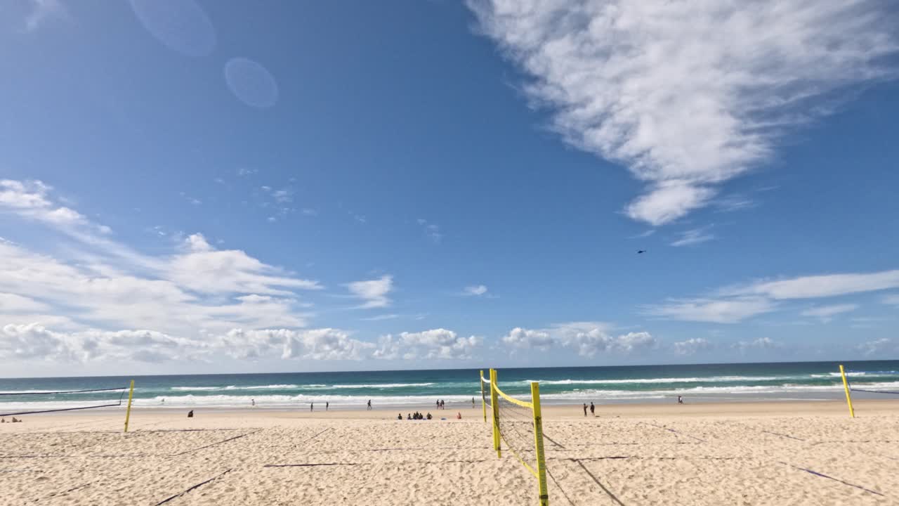 이 많은 해변에서 배구 를 하는 사람 들