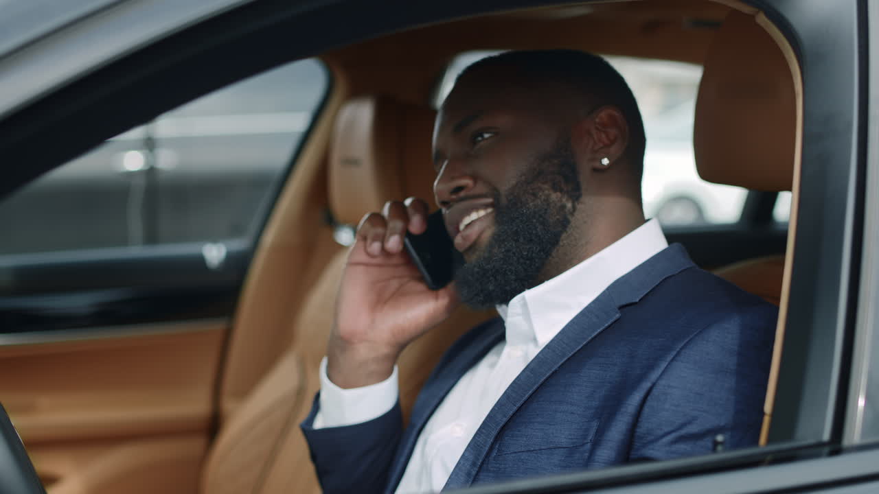 Closeup african man using phone at car. African man talking mobile at vehicle