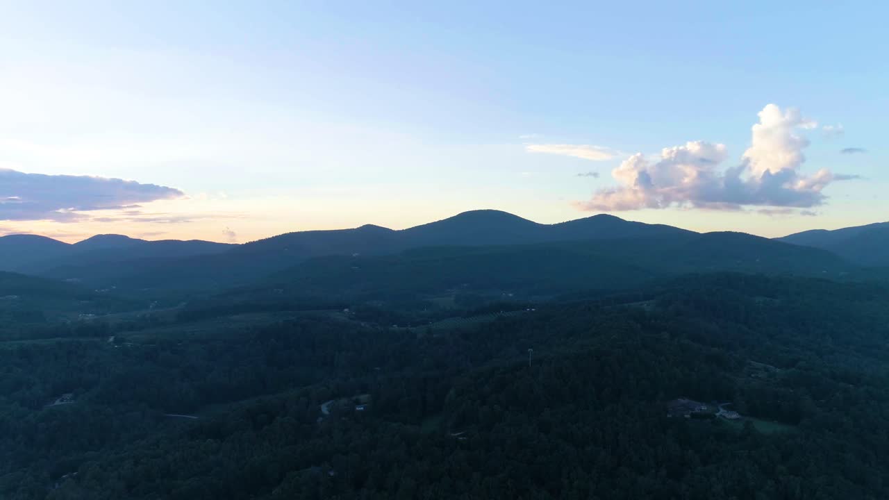 Drone flying through a mountain range at sunset.