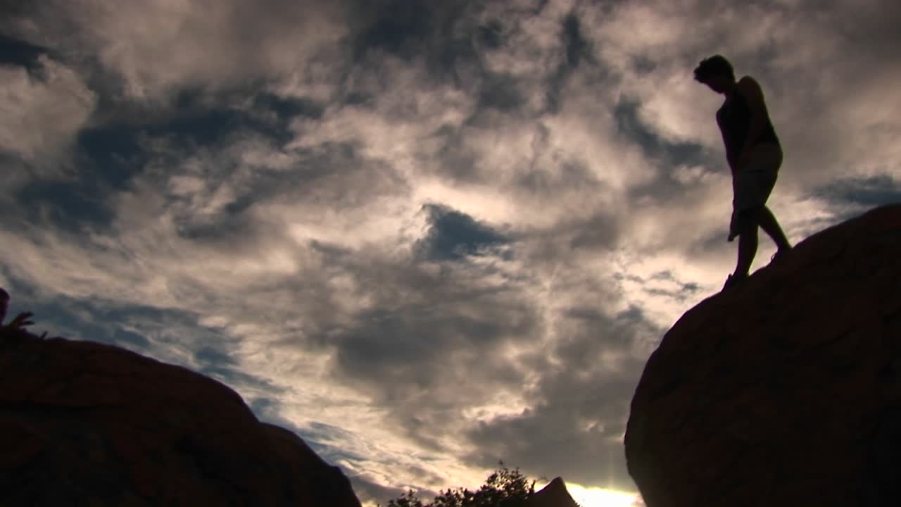 lowangle de un excursionista en las montañas de santa bárbara saltando de roca en roca