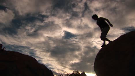 lowangle de un excursionista en las montañas de santa bárbara saltando de roca en roca