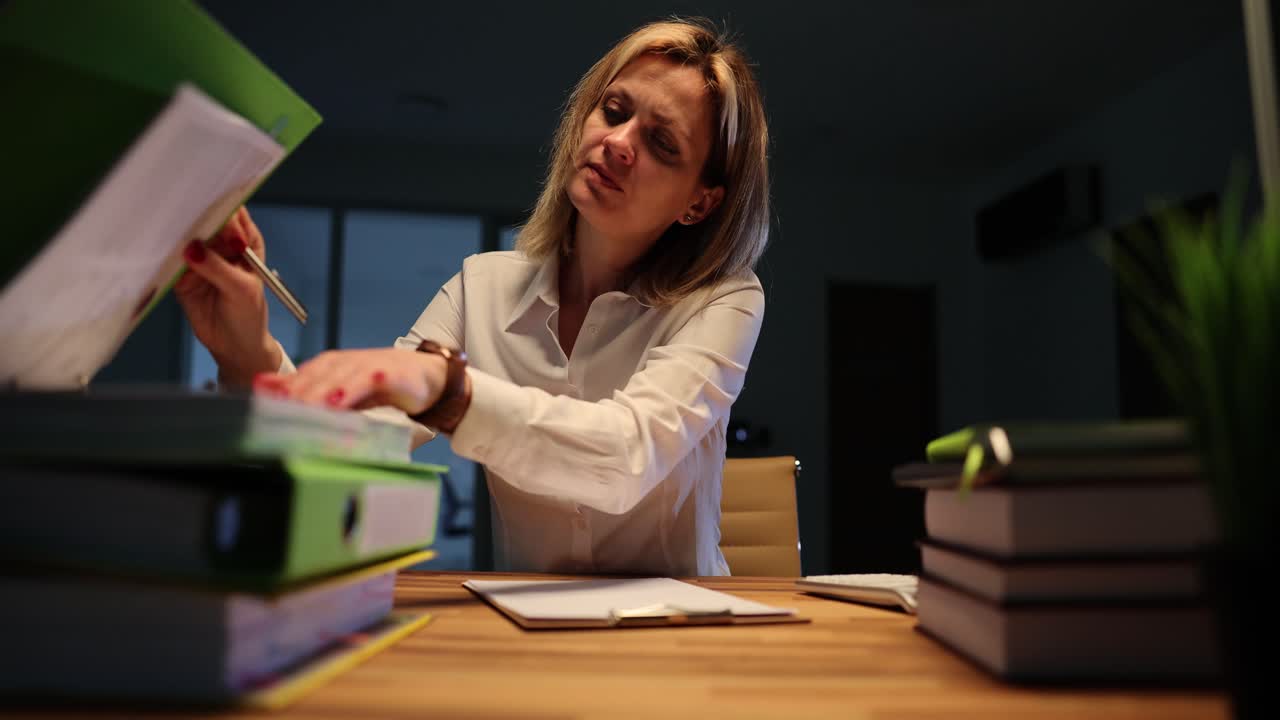 Concentrated woman writes report during lightning flashes