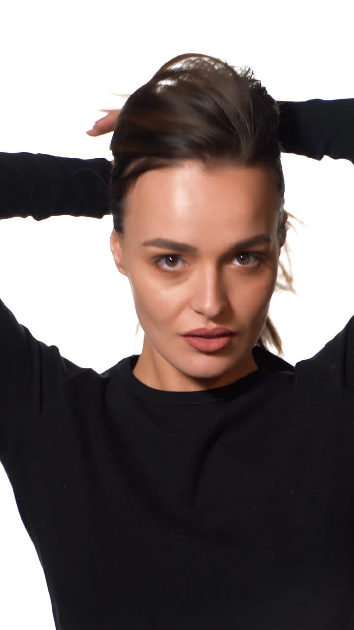 Woman posing isolated on background. Portrait of gorgeous young brunette woman with healthy hair. Vertical video