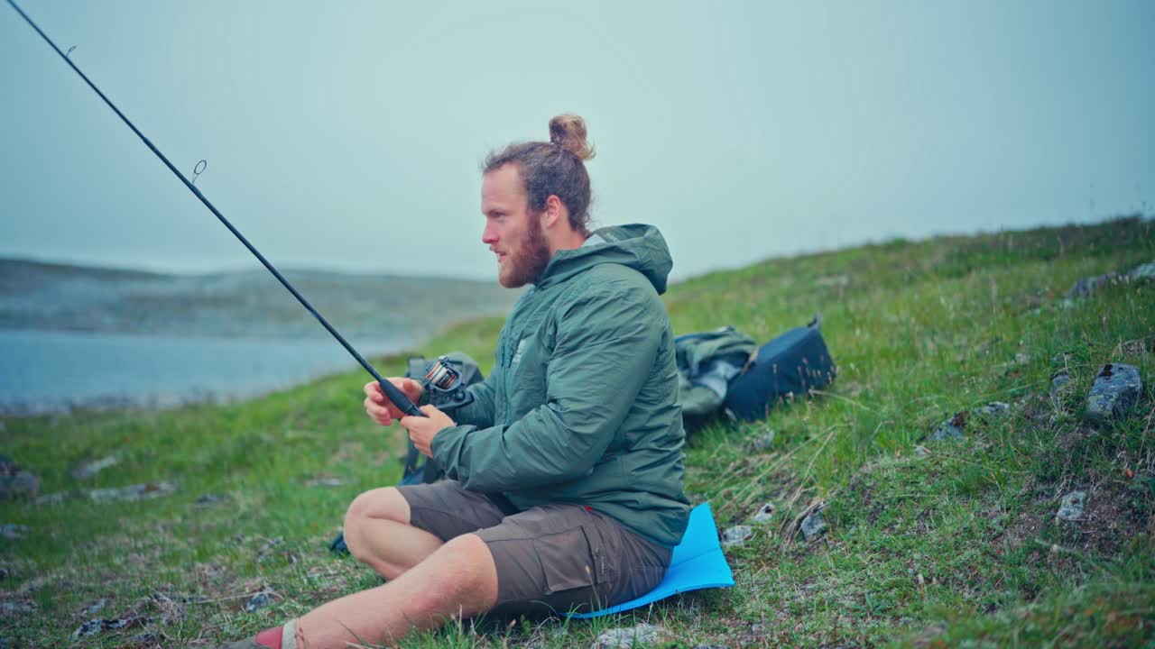 Man Fishing By The Lake, Havvatnet Lake In Norway - Wide Shot