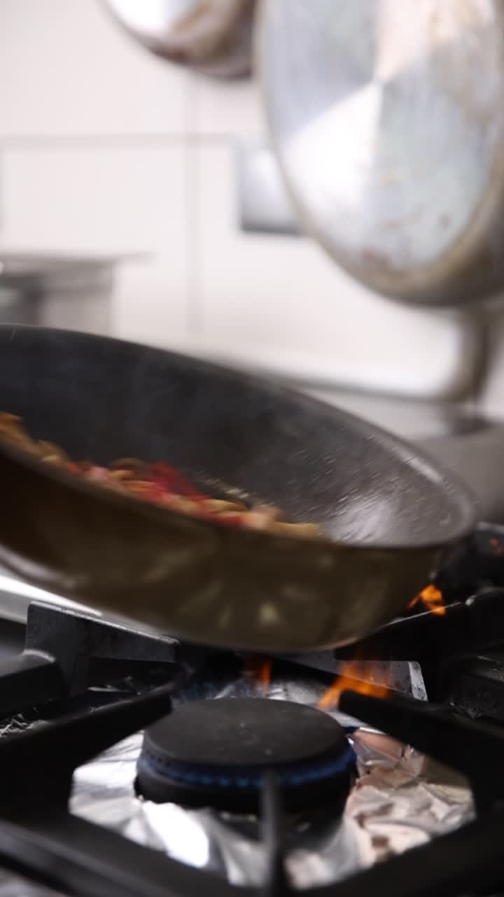 Primo piano di cibo saltato in padella su un fornello a gas