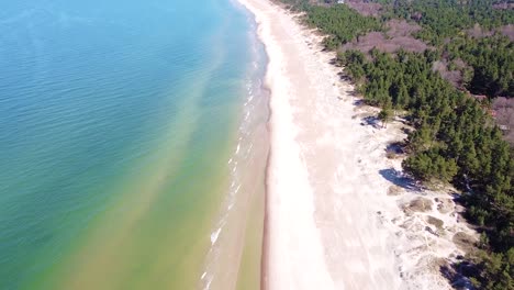 calm sea water and sandy coastline of baltic sea in aerial view