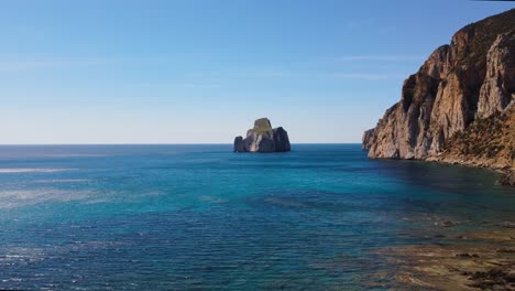 Masua-4k-aerial-drone-view-of-sea-stack-on-a-sunny-day,-Sardinia-coast