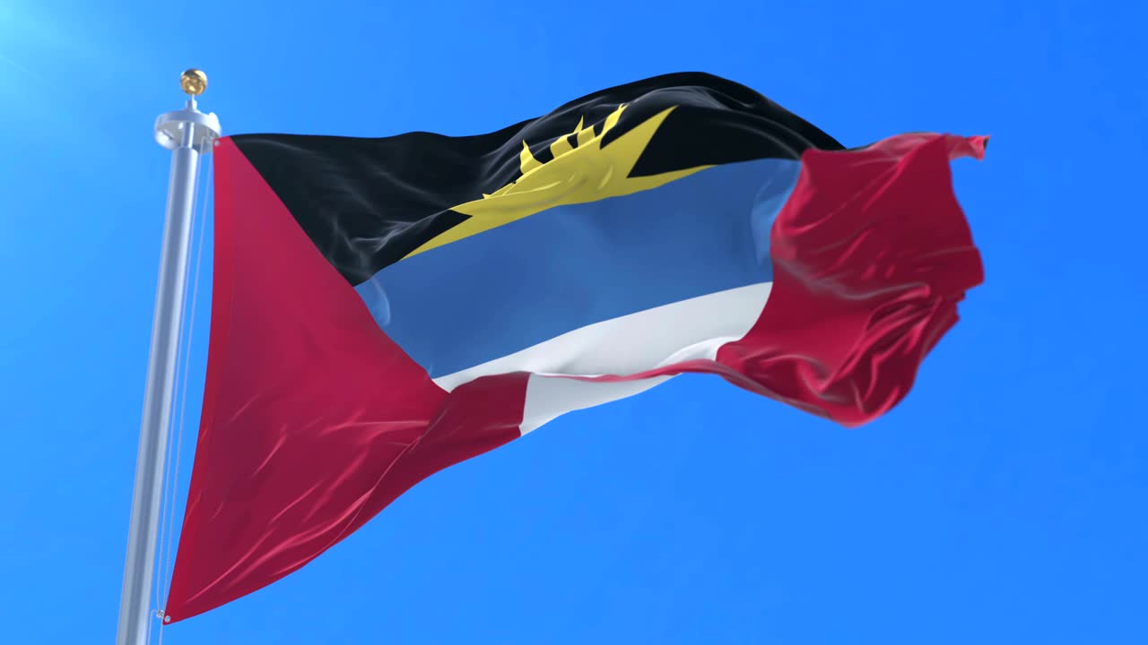 y la bandera de antigua y barbuda agitando el viento lentamente con el cielo azul, bucle